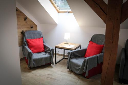 a attic room with two chairs and a table at Sosnówka Pokoje Gościnne in Borne Sulinowo