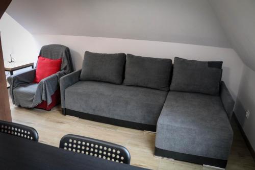 a living room with a couch and a chair at Sosnówka Pokoje Gościnne in Borne Sulinowo