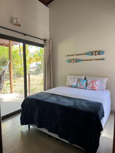 Un dormitorio con una cama y una puerta corrediza de vidrio. en Pé de Serra Beach House - Serra Grande, en Serra Grande