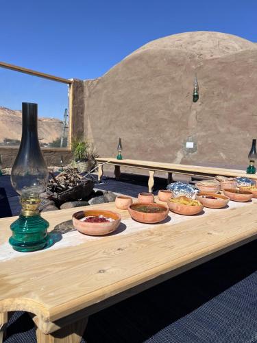 a wooden table with bowls of food on it at Nala Narty Boutique Hotel & Farm in Aswan