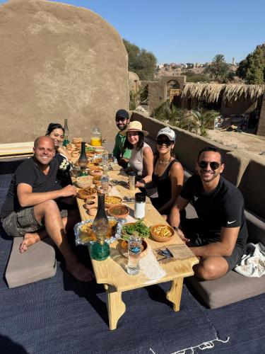 a group of people sitting around a table with food at Nala Narty Boutique Hotel & Farm in Aswan