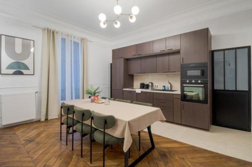 une cuisine avec une table et des chaises dans une pièce dans l'établissement Mobility lease - La Fayette - 8 people, à Paris