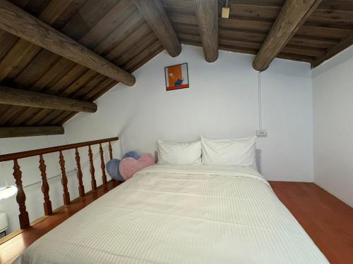 a large bed in a room with wooden ceilings at 金門 湖光悠宅古厝民宿 Relax Lake B&B in Lin-ts'o