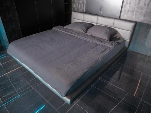 a large bed in a room with a tiled floor at Behind the Scenes Taczaka in Poznań