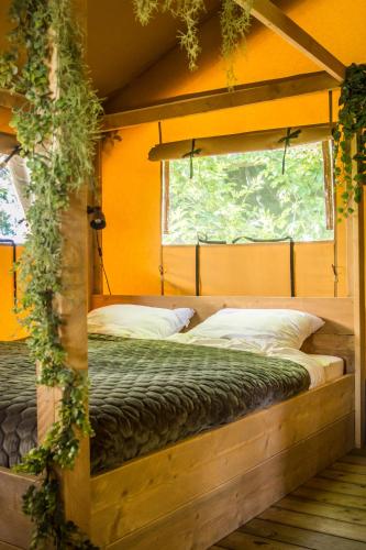a bedroom with two beds and a window at Boeren glamping De Ruif De zilverberk in Stoutenburg