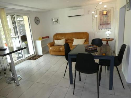 un salon avec une table et un canapé dans l'établissement Appartement moderne à Latresne avec jacuzzi, 50 m², à Latresne