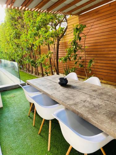 a long table and chairs in a backyard with at Elegant and Private Living by Neuvel in Athens