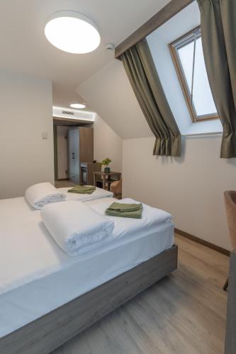 two beds in a room with a large window at Turul Villa in Sovata