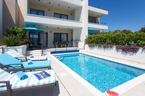 a villa with a swimming pool and a house at Villa Lemon Tree in Vinišće