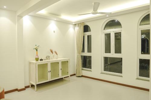 a living room with white walls and windows at VILLA M- SAVANNAH 7- 5BHK Brand New Villa in Calangute with Private Pool, Near Beach, free Breakfast, north goa in Goa