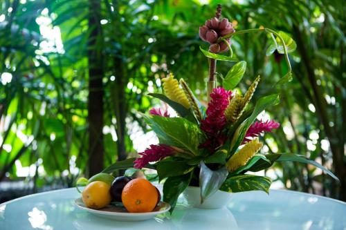 un cesto di frutta e un vaso di fiori su un tavolo di Jacana Amazon Wellness Resort a Paramaribo