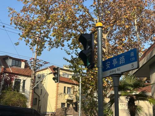 a traffic light and a street sign on a pole at villa with perfect garden in XUHUI nearby art museum in Shanghai