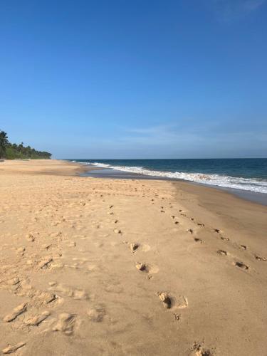 a pair of footprints in the sand on a beach at Seth Villa by Magampura Resorts in Tangalle