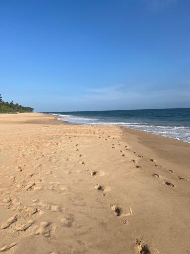 a pair of footprints in the sand on the beach at Seth Villa by Magampura Resorts in Tangalle