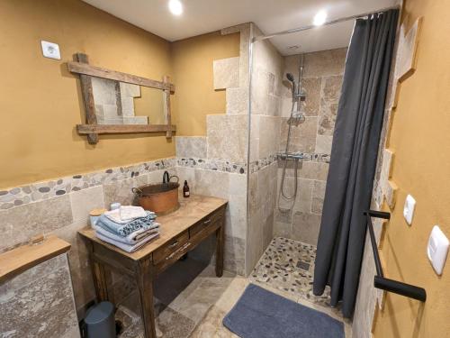 bagno con doccia, tavolo in legno e lavandino di Chambre d'Art a Friaudour