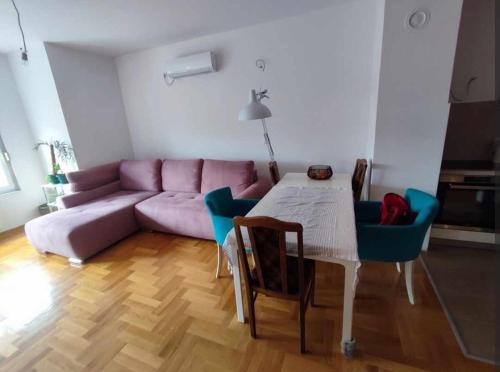 Una sala de estar con un sofá rosa y una mesa. en Room in a nice sunny apartment, en Vračar (historical)