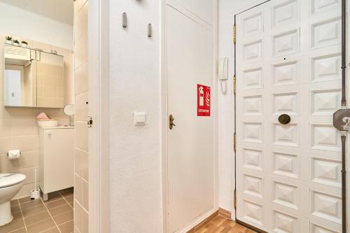 a bathroom with a white door and a toilet at Estudio Lighthouse F77 A109 in Torrox Costa
