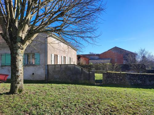 un arbre dans un champ à côté d'un bâtiment dans l'établissement Gite Meuz' Friendly, à Laimont