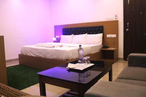 ein Hotelzimmer mit einem Bett und einem Couchtisch in der Unterkunft Guest House Baptice Inn in Khānāpāra
