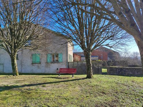 un banc rouge devant une maison dans l'établissement Gite Meuz' Friendly, à Laimont