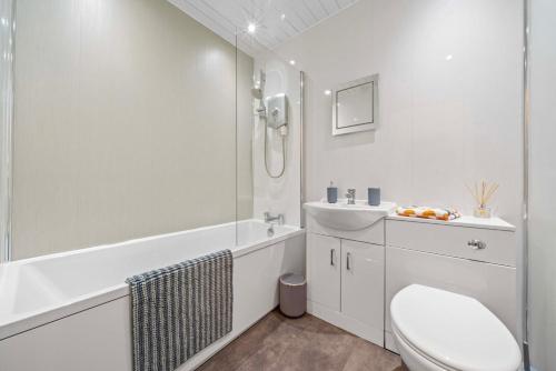 a white bathroom with a toilet and a sink at Central Kirkintilloch 2 Bed App in Kirkintilloch