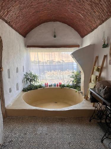 a large bath tub in a room with a window at Nala Narty Boutique Hotel & Farm in Aswan