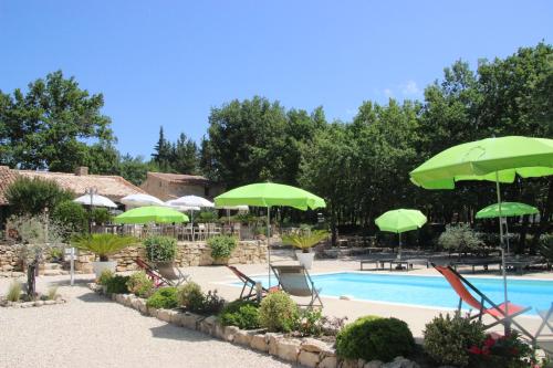 - une piscine bordée de parasols et de chaises verts dans l'établissement Suite Fleur de Cerisier, à Gordes