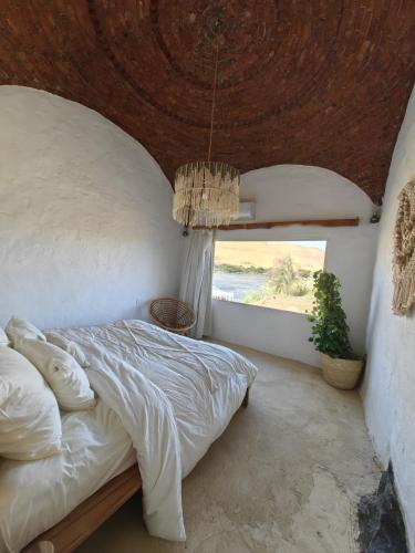 a bedroom with a bed with a large window at Nala Narty Boutique Hotel & Farm in Aswan