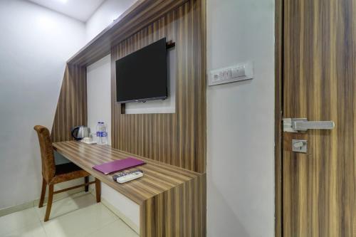 a room with a desk and a tv on a wall at Hotel Blue Saphire Terminal 2 in Mumbai