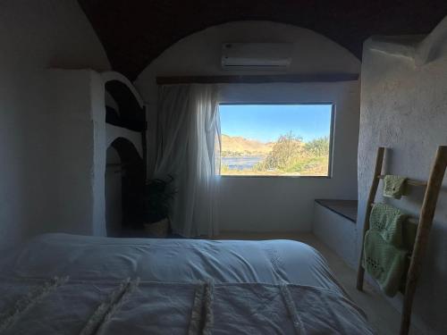 a bedroom with a bed and a window at Nala Narty Boutique Hotel & Farm in Aswan
