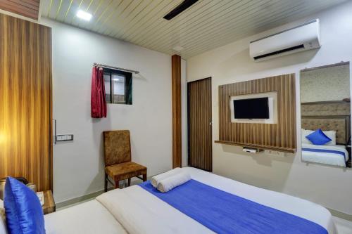 a bedroom with a large bed and a chair at Hotel Blue Saphire Terminal 2 in Mumbai