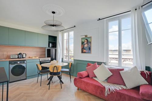 un salon avec un canapé rouge et une table dans l'établissement Le Mona - Entre Paris & Disney - Wifi, à Villemomble