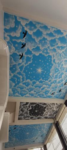 a room with a ceiling with birds flying in the sky at Geeta Teerth Guest House AC and Non AC Rooms in Ayodhya