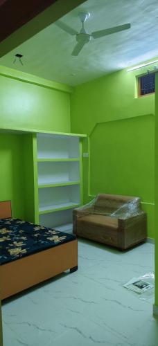 a green bedroom with a bed and a ceiling fan at Geeta Teerth Guest House AC and Non AC Rooms in Ayodhya