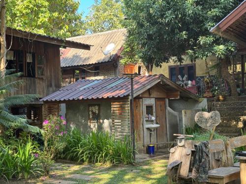 a house with a motorcycle parked in front of it at Ban Kaew Mo Ra Glamping & Restaurant in Pang Mapha