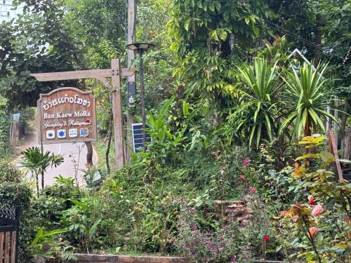 a sign for a garden with flowers and plants at Ban Kaew Mo Ra Glamping & Restaurant in Pang Mapha