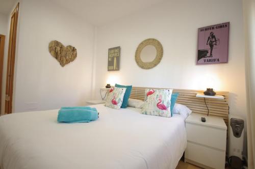 sypialnia z białym łóżkiem z poduszkami w obiekcie Livingtarifa Apartamento Paradise w mieście Tarifa