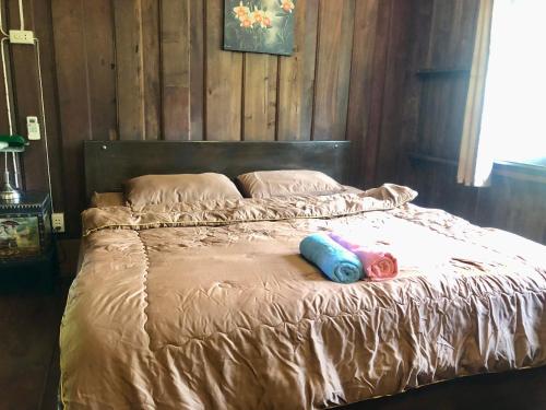a bed with two pillows on top of it at Ban Kaew Mo Ra Glamping & Restaurant in Pang Mapha