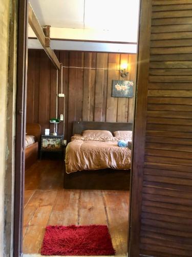 a bedroom with a bed and a red rug at Ban Kaew Mo Ra Glamping & Restaurant in Pang Mapha