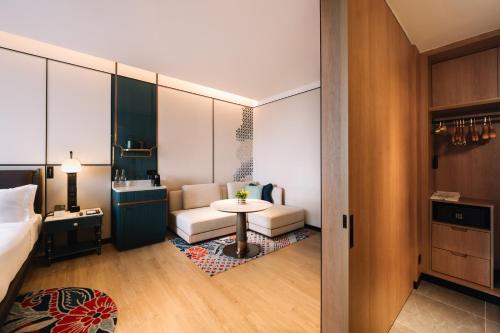 峇六拜Iconic Marjorie Hotel, Penang, a Tribute Portfolio Hotel的配有床、桌子和沙发的房间