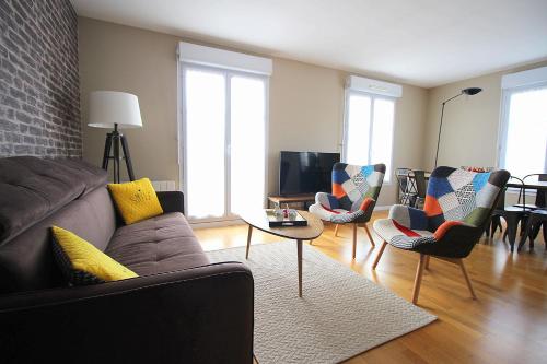 un salon avec un canapé, des chaises et une télévision dans l'établissement TAGE8 Disneyland Paris for 8 people, à Serris