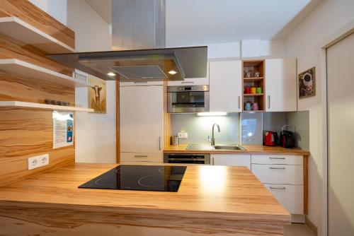 a kitchen with white cabinets and a wooden counter top at Appartement Klosterhügel in Haus im Ennstal