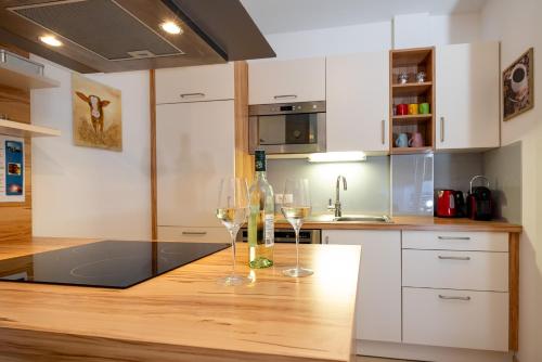 a kitchen with two wine glasses on a wooden table at Appartement Klosterhügel in Haus im Ennstal