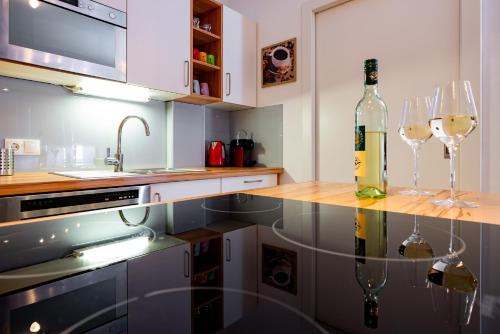 a kitchen with two wine glasses and a bottle of wine at Appartement Klosterhügel in Haus im Ennstal