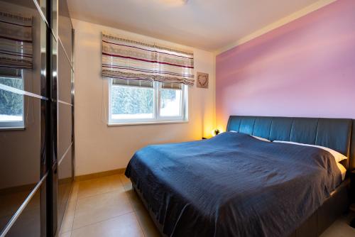 a bedroom with a blue bed and a window at Appartement Klosterhügel in Haus im Ennstal