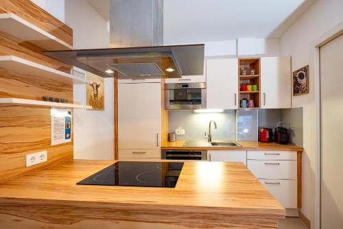 a kitchen with white cabinets and a wooden counter top at Appartement Klosterhügel in Haus im Ennstal