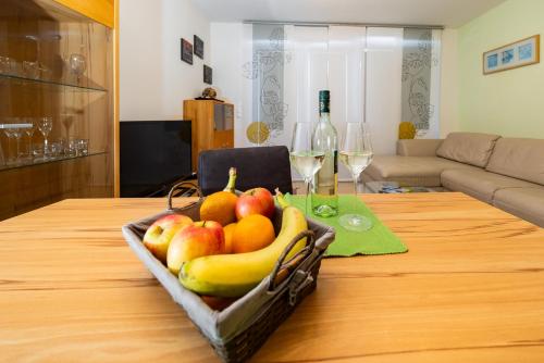 a basket of fruit on a table with wine glasses at Appartement Klosterhügel in Haus im Ennstal