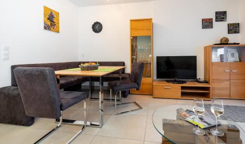 a living room with a table and a television at Appartement Klosterhügel in Haus im Ennstal