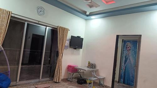 una habitación con un reloj en la pared y una mesa en Adviks Home Stay, en Alibaug
