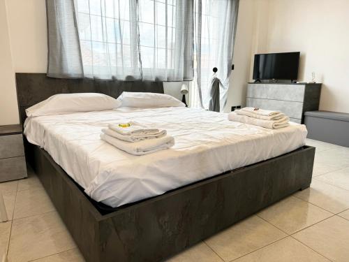 a bedroom with a large bed with towels on it at Residenza Dartuffo - Apartment - City Centre in Scilla